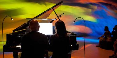 Maki Namekawa and Dennis Russell Davies playing piano