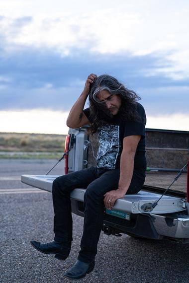 Raven Chacon sitting on pickup truck.
