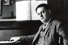 Darius Milhaud at piano with score.