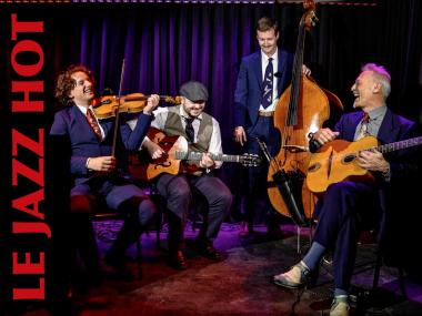 Four musicians on stage with string instruments
