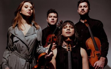 The Attaca Quartet in black and grey with their violins.
