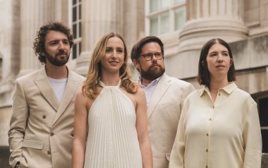 Castalian String Quartet in white and creme outfits standing together.