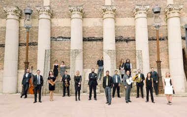 Taproot Musicians standing in formal clothes in front of a brick building.