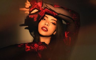 Lucía in a red and black top staring at the camera.