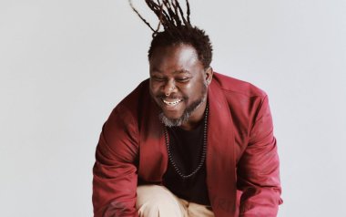 Okaidja Afroso smiling and jumping in the air.