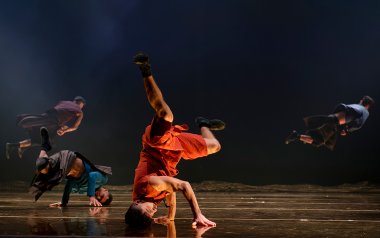 dancer is balancing on his head on stage.
