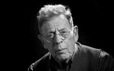 Portrait of Philip Glass in black and white. 