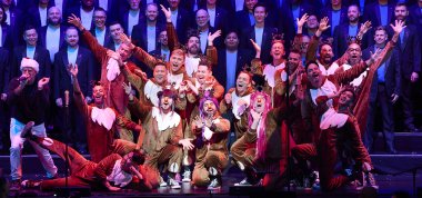 The choir is posing in the center of the stage n reindeer costumes