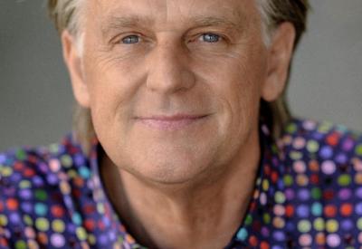 A portrait of pianist Stephen Prutsman, wearing a colorful polka dotted shirt