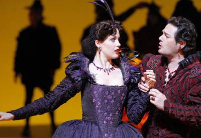 A photograph of Pene Pati as the Duke of Mantua and Zanda Svede as Maddalena in Verdi's "Rigoletto." The two stand close, gazing at one another as the Duke of Mantua clutches Maddalena's hand. Photo by Cory Weaver/San Francisco Opera