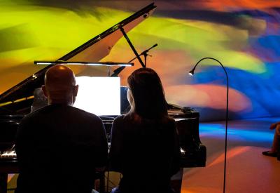 Maki Namekawa and Dennis Russell Davies playing piano