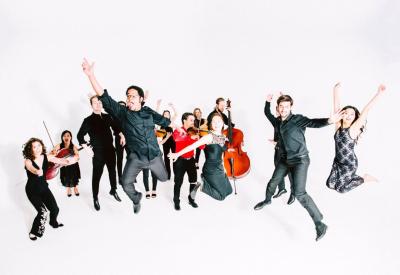 Image of Delirium Musicum musicians joyfully jumping in the air with their instruments