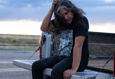 Raven Chacon sitting on pickup truck.