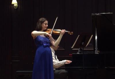 Musician Dorisiya Yosifova playing violin with a grand piano accompaniment