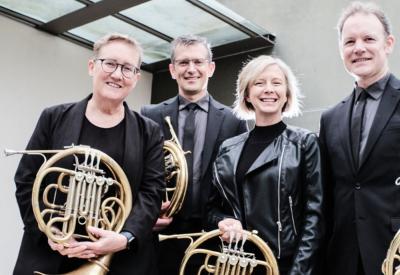 The group Quadre is shown with four french horns.