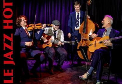 Four musicians on stage with string instruments