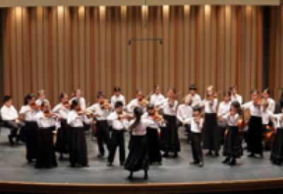 The Colburn Community School Suzuki students performing on stage.