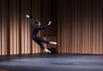 A dance student mid-air in a leap.