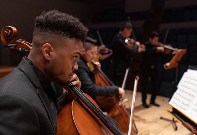 Man playing cello looking at sheet music Credit Scott Jackson
