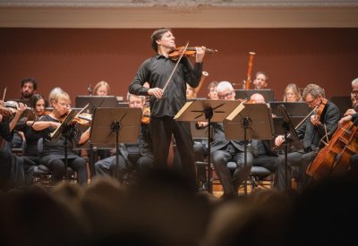 Joshua Bell playing his violin centered around the Academy of St Martin in the Fields musicians.