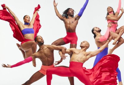 Alvin Ailey dancers jumping and doing tricks in red, purple, and pink dancewear.