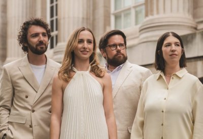 Castalian String Quartet in white and creme outfits standing together.