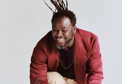 Okaidja Afroso smiling and jumping in the air.