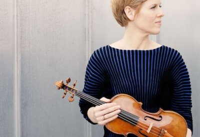white woman wearing a blue sweater holding a violin