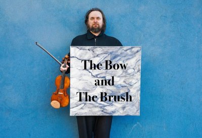 Daniel Flanagan poses with his violin and a painting by Rachel Dwan
