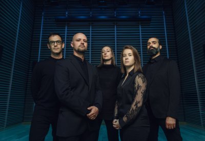 Five musicians in a dark room with blue lighting, trying to look tough to suggest the edginess of their programming