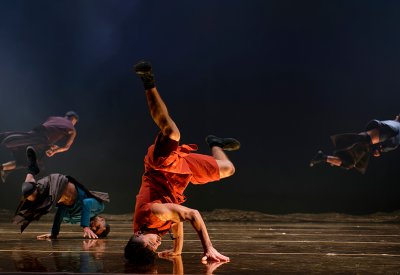 dancer is balancing on his head on stage.