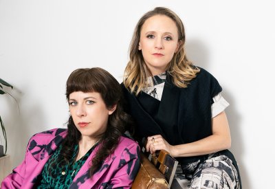 Missy Mazzoli and Ellen Reid posing together in front of a white wall