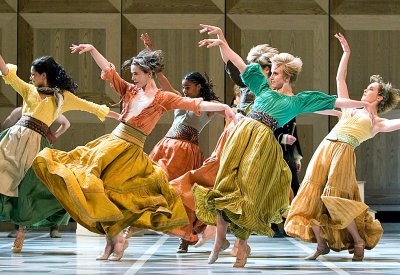 Dancers in colorful skirts are dancing with their hands up