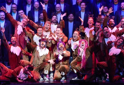 The choir is posing in the center of the stage n reindeer costumes