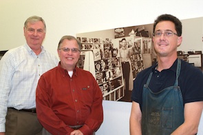 Co-owners Rich Welker and Don Edwards and repairman Ron Graham pose alongside a portrait of Milton Bronstein at the store he founded in 1946<br>Photo by Jeff Kaliss Bronstein Music Store